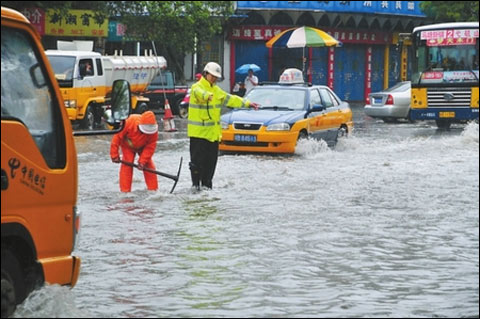 6月18日，芜湖市中二街积水很深，交警正在指挥交通。