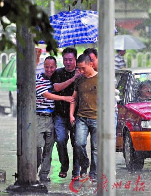 暴雨中几名男子共享一伞