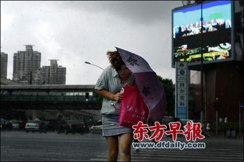 昨天，一场暴雨袭来，上海市凯旋路长宁路，一名路人顶风前行。早报记者 王辰 图