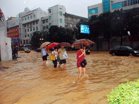 9月1日，在福建省莆田市城厢区霞林街道，市民在被洪水淹没的街道上前行。