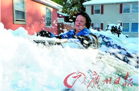 美国一家庭妇女在院子里扫雪