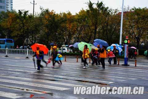 学生们打着雨伞过马路（宫举卫 摄）