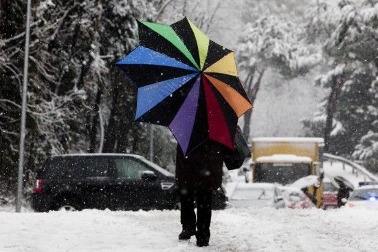 2月3日，行人冒雪走在意大利罗马街头