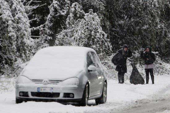 2月3日，两位女士冒雪站立在意大利罗马街头